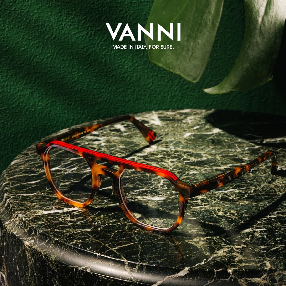 Tortoiseshell-patterned VANNI optical frame with a bright red brow accent on veined green marble