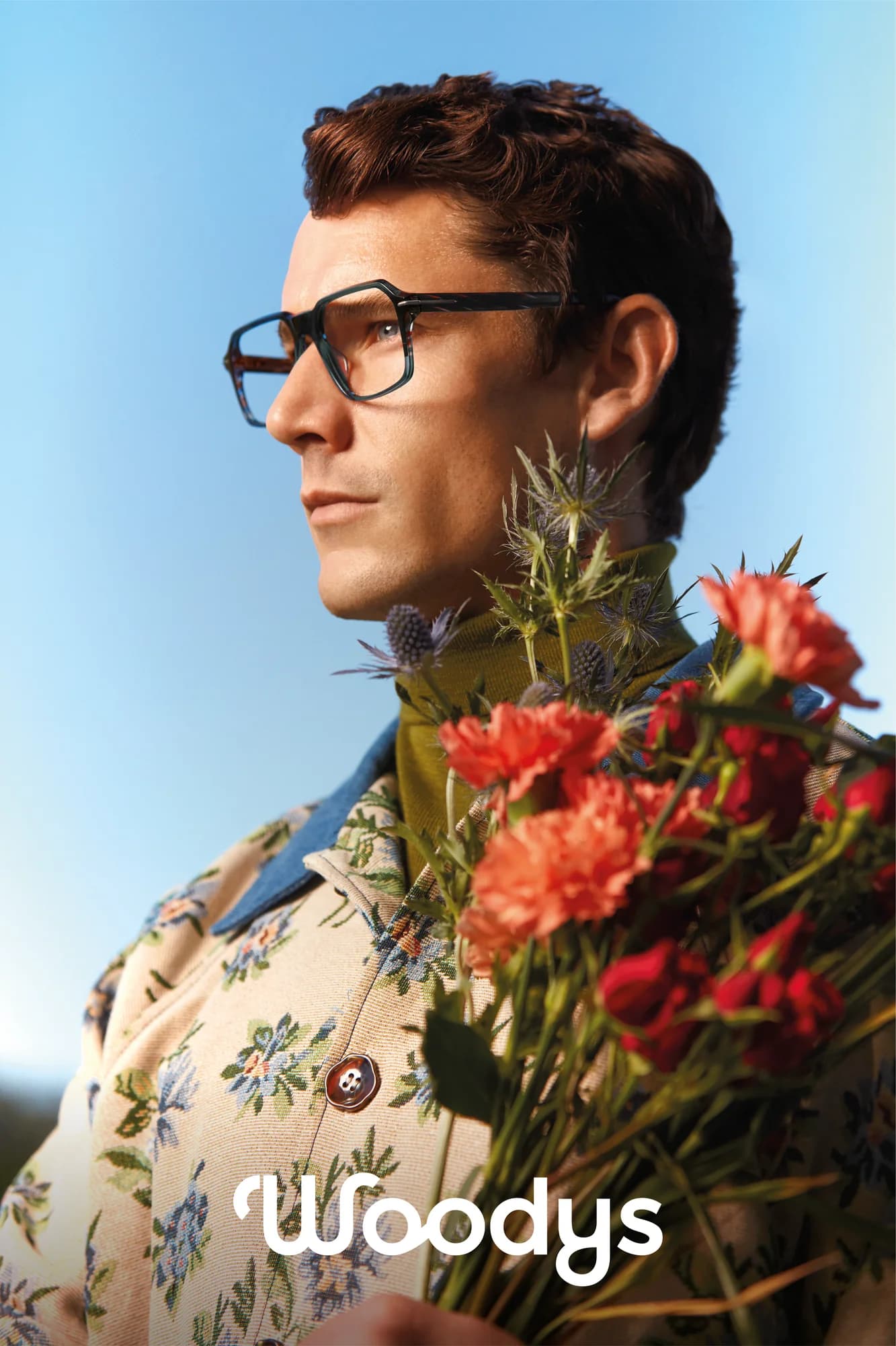 Woodys Tarantino optical frame shown in profile beside a bouquet of red and blue flowers