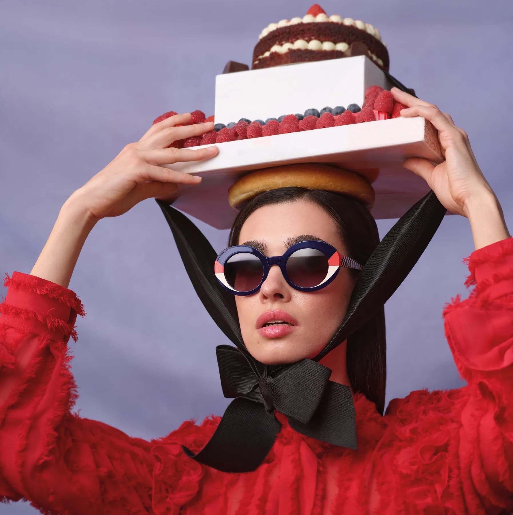 Woodys Unique Bakery SS26 sunglasses campaign image with a model in red styling